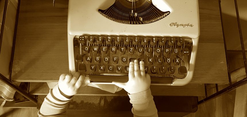 Babyhände auf Schreibmaschine